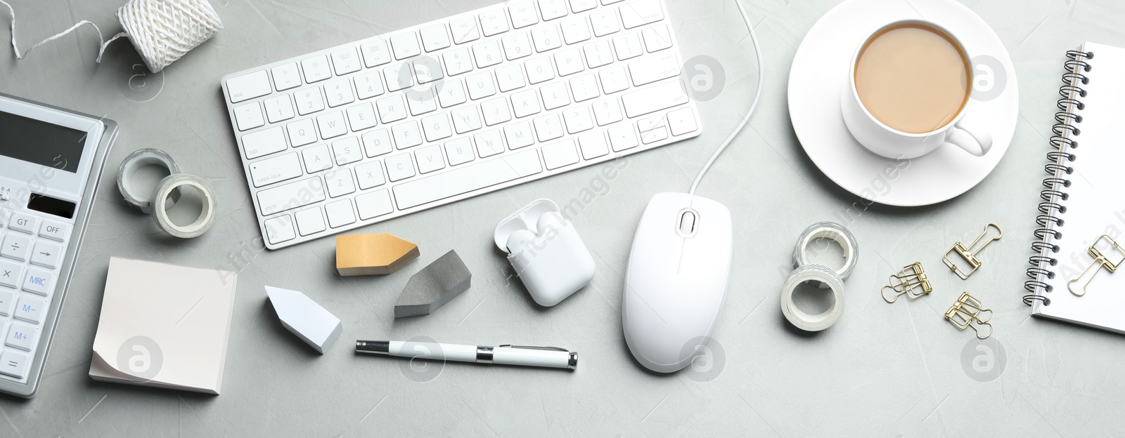 Photo of Flat lay composition with wired computer mouse and stationery on light grey table. Space for text