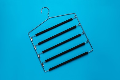 Photo of Empty hanger on light blue background, top view