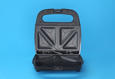 Open sandwich maker on light blue background