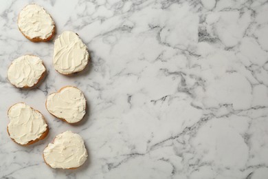 Delicious sandwiches with cream cheese on white marble table, flat lay. Space for text