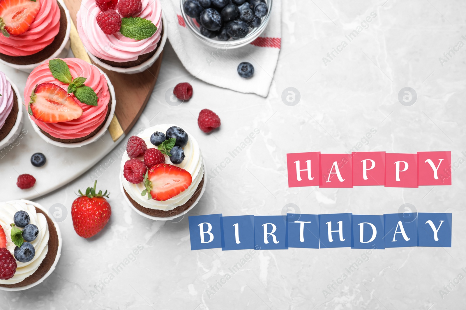 Image of Happy Birthday. Sweet cupcakes with fresh berries on light marble table, flat lay