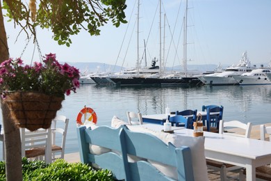 Photo of Beautiful view of outdoor cafe near pier with different boats