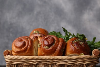Photo of Delicious pampushky (buns) in wicker basket, closeup. Space for text