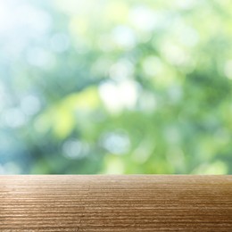 Image of Empty wooden surface against blurred green background. Bokeh effect