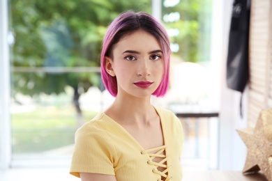 Photo of Young woman with color hair in beauty salon. Modern trend