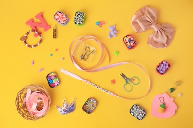 Handmade jewelry kit for kids. Colorful beads, ribbon and different supplies on orange background, flat lay