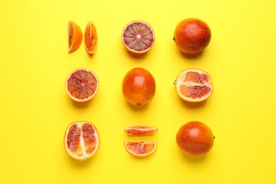 Photo of Many ripe sicilian oranges on yellow background, flat lay