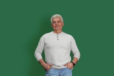 Photo of Portrait of handsome mature man on color background