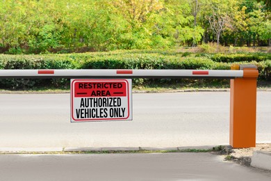 Sign with text Restricted Area Authorized Vehicles Only on boom barrier outdoors