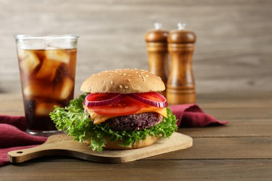 Photo of Tasty vegetarian burger with beet patty served on wooden table. Space for text