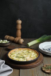 Tasty leek pie, fresh stalk and thyme on wooden table