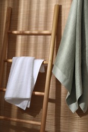 Photo of Soft terry towels and wooden ladder indoors
