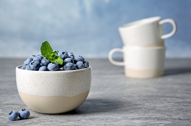 Photo of Juicy and fresh blueberries with green leaves on blurred background