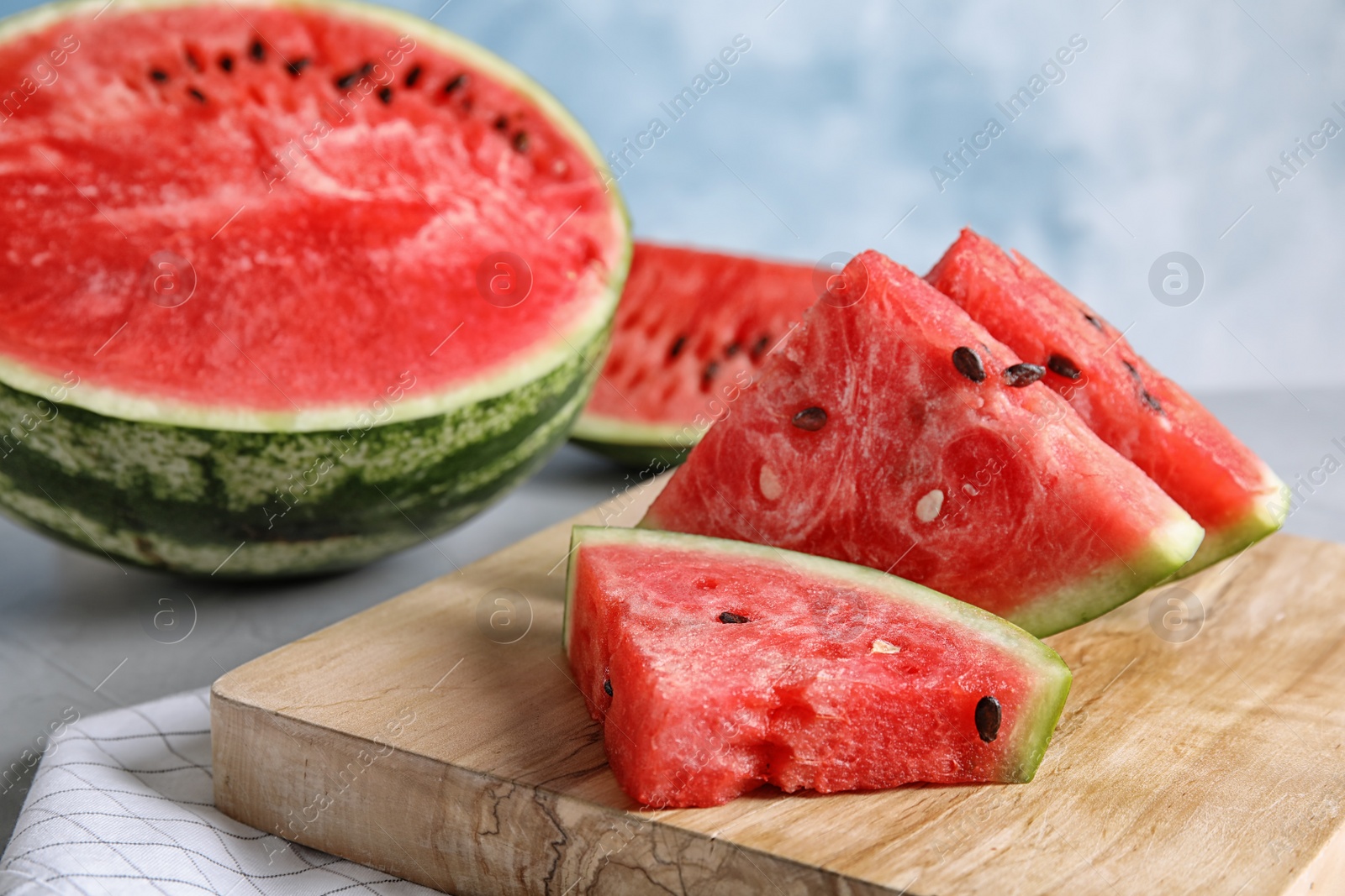 Photo of Wooden board with juicy watermelon slices on table