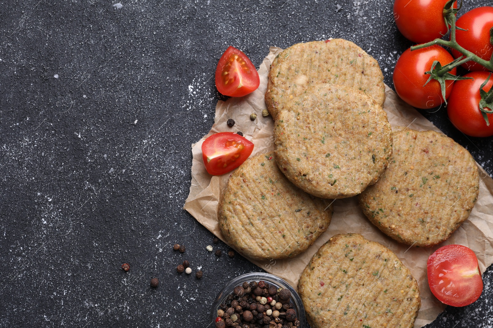 Photo of Tasty vegan cutlets and products on grey table, flat lay. Space for text