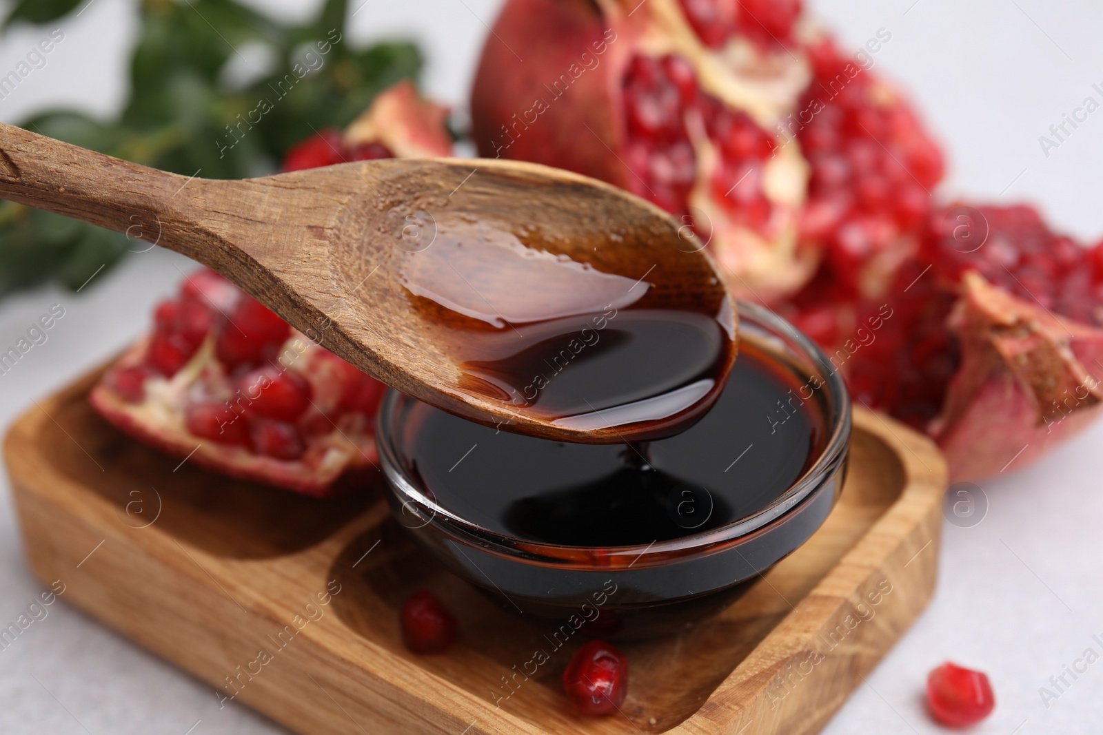 Photo of Tasty pomegranate sauce on light table, closeup