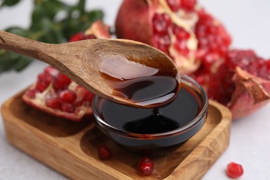 Photo of Tasty pomegranate sauce on light table, closeup