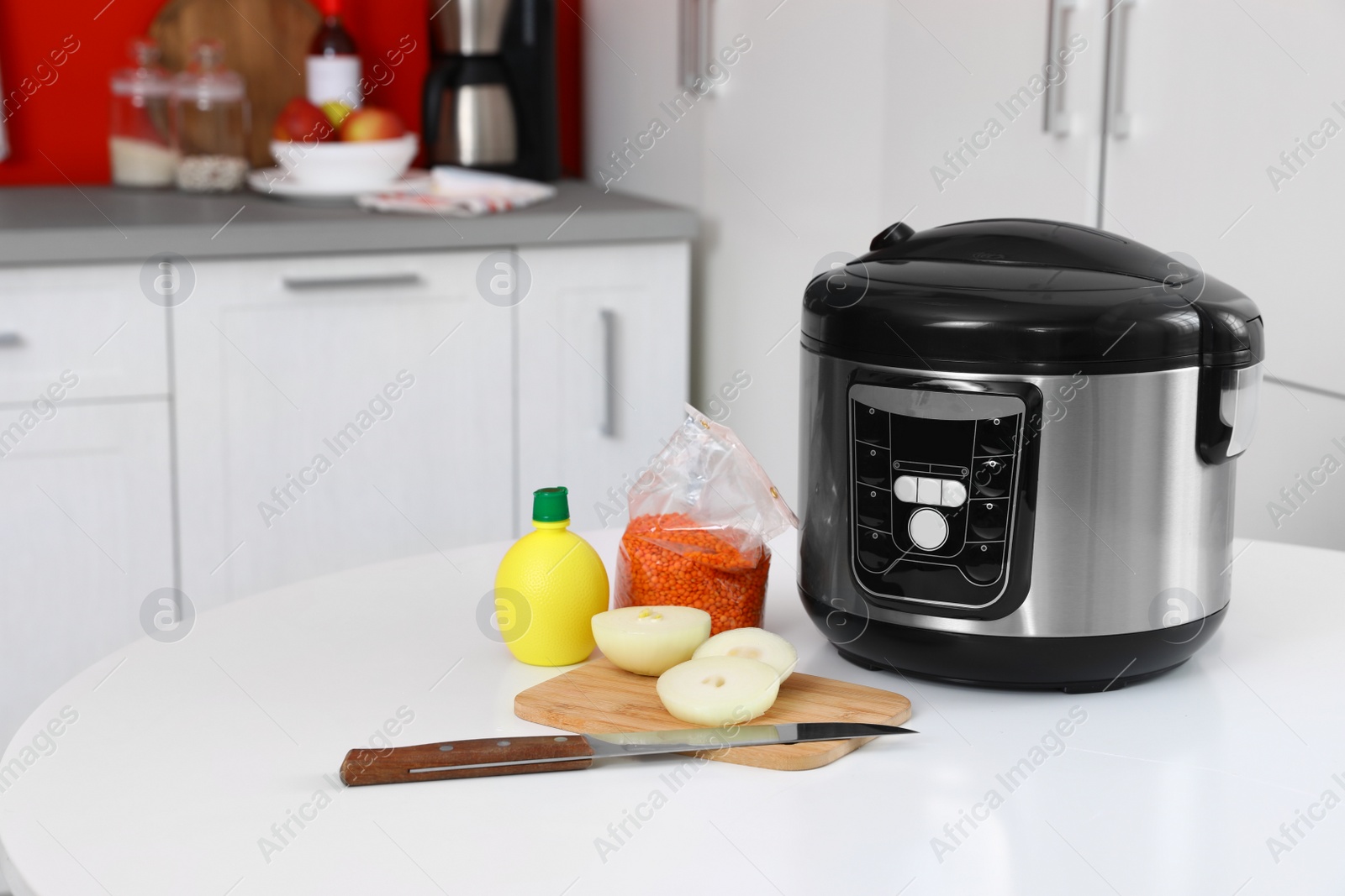 Photo of New modern multi cooker and products on table in kitchen. Space for text