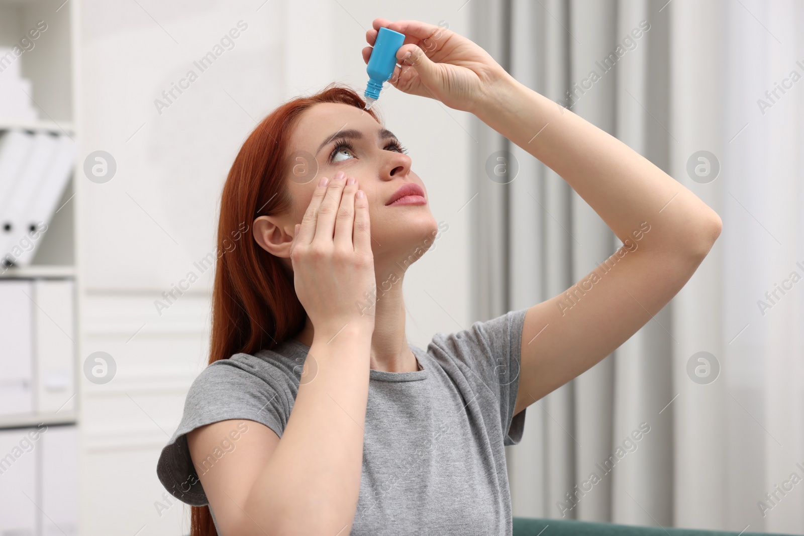 Photo of Woman applying medical eye drops at home