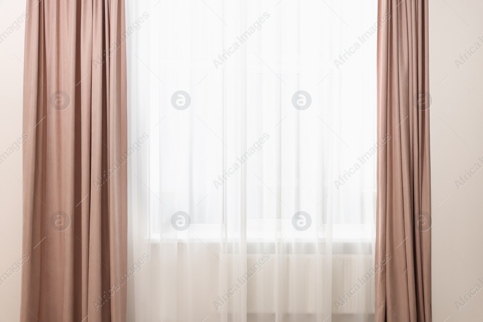 Photo of Elegant window curtains and white tulle indoors. Interior design