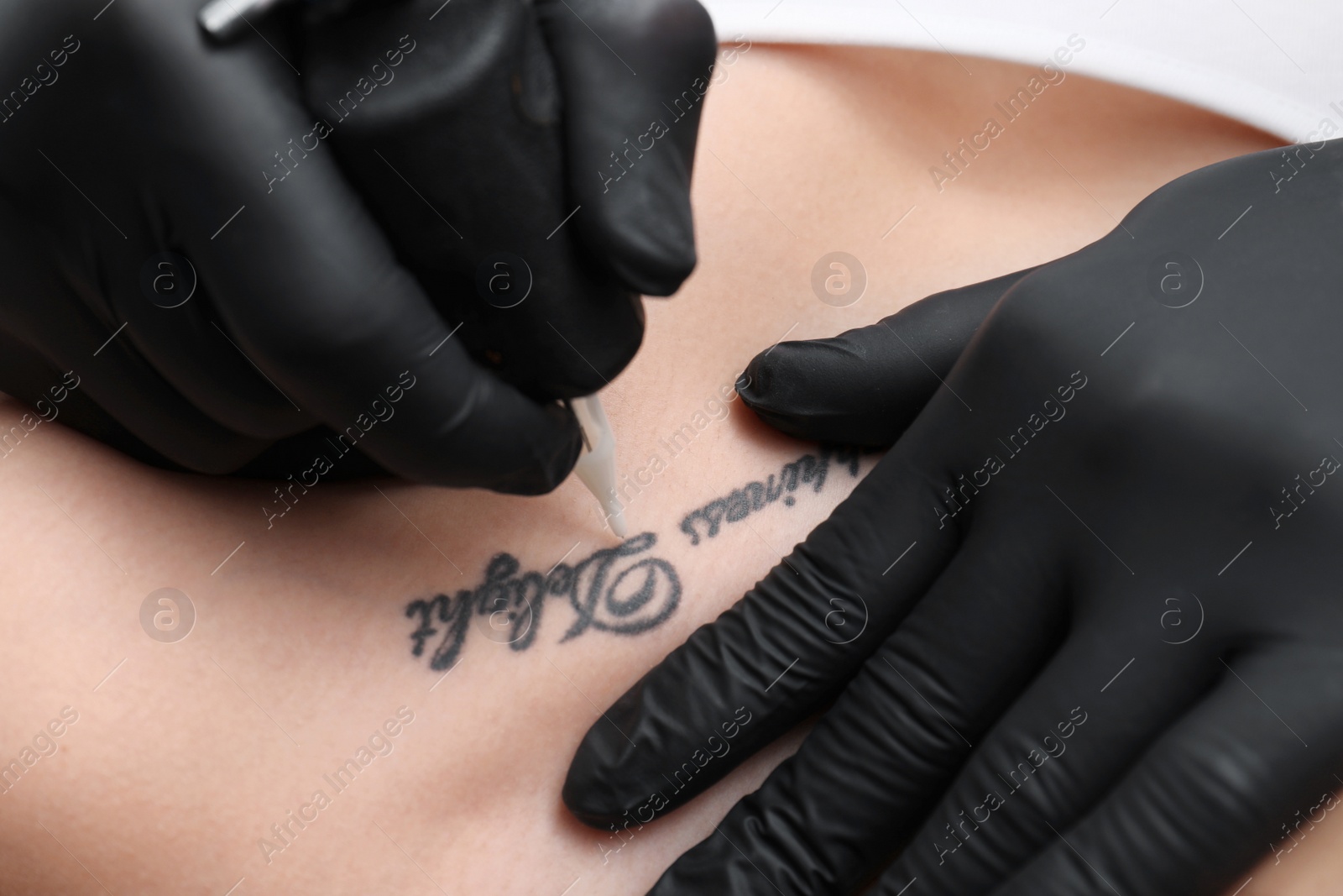 Photo of Professional artist making tattoo in salon, closeup