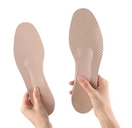 Photo of Woman holding pair of pink orthopedic insoles on white background, closeup