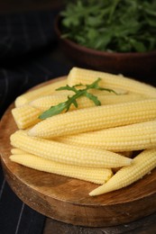 Photo of Tasty fresh yellow baby corns on wooden table, closeup