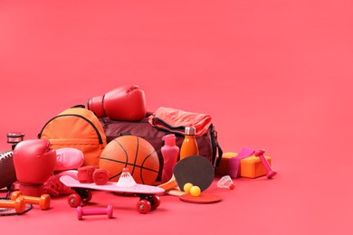 Many different sports equipment on red background, space for text