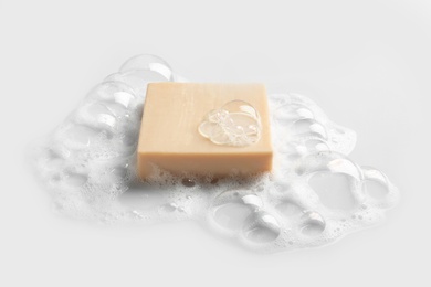Photo of Soap bar and foam on white background