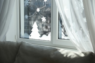 Photo of Beautiful drawing made of artificial snow on window at home. Christmas decor