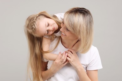 Photo of Family portrait of happy mother and daughter on grey background