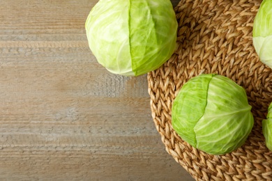 Photo of Ripe white cabbage on wooden table, flat lay. Space for text