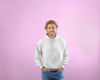 Photo of Portrait of man in hoodie sweater on color background. Space for design