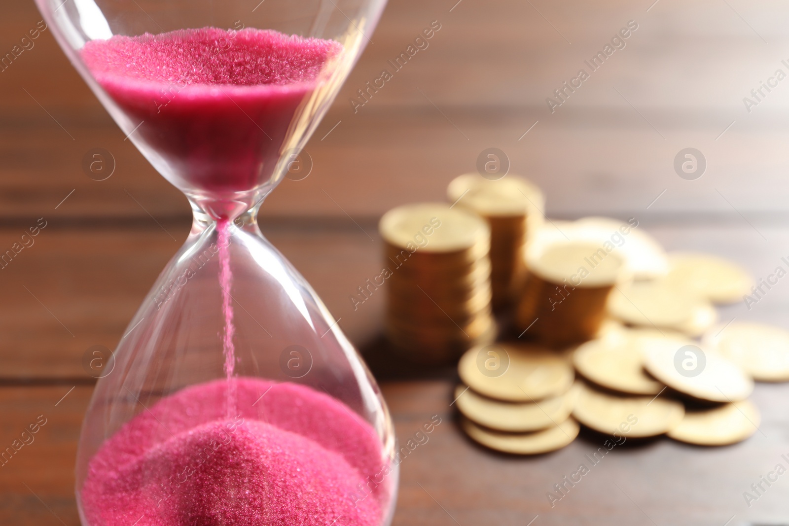 Photo of Hourglass with flowing sand on table, closeup. Time management