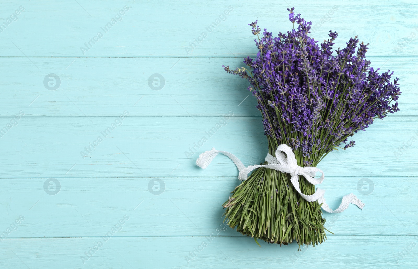 Photo of Beautiful lavender bouquet on light blue wooden background, top view. Space for text