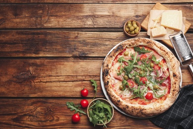 Photo of Tasty pizza with meat and arugula on wooden table, flat lay. Space for text