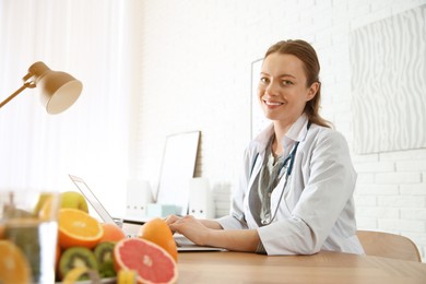 Image of Nutritionist working with laptop at desk in office