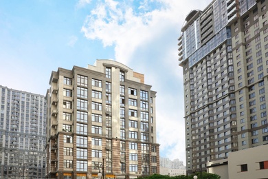 Photo of Modern buildings with tinted windows against sky. Urban architecture