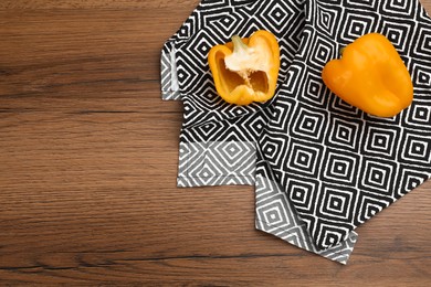 Photo of Kitchen towel and bell peppers on wooden table, flat lay. Space for text
