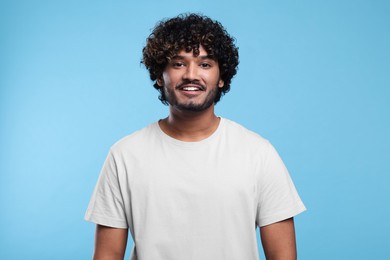 Photo of Handsome smiling man on light blue background