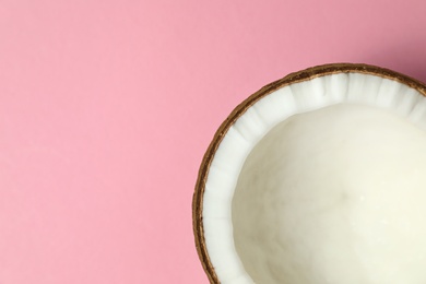 Photo of Fresh coconut half on pink background, top view. Space for text