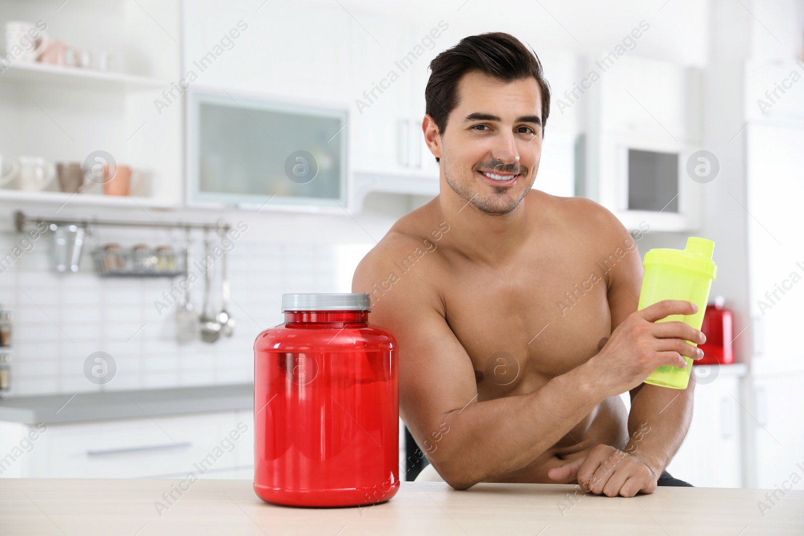 Photo of Young shirtless athletic man with protein shake powder in kitchen, space for text