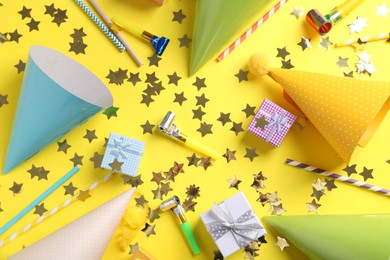 Photo of Flat lay composition with party hats on yellow background