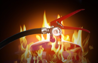 Image of Fire extinguisher surrounded by flame on dark background