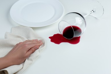 Photo of Woman cleaning spilled wine on white background, closeup