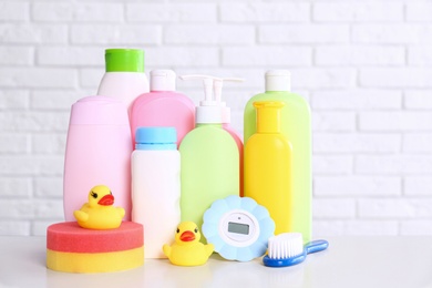 Photo of Baby accessories on table near white brick wall