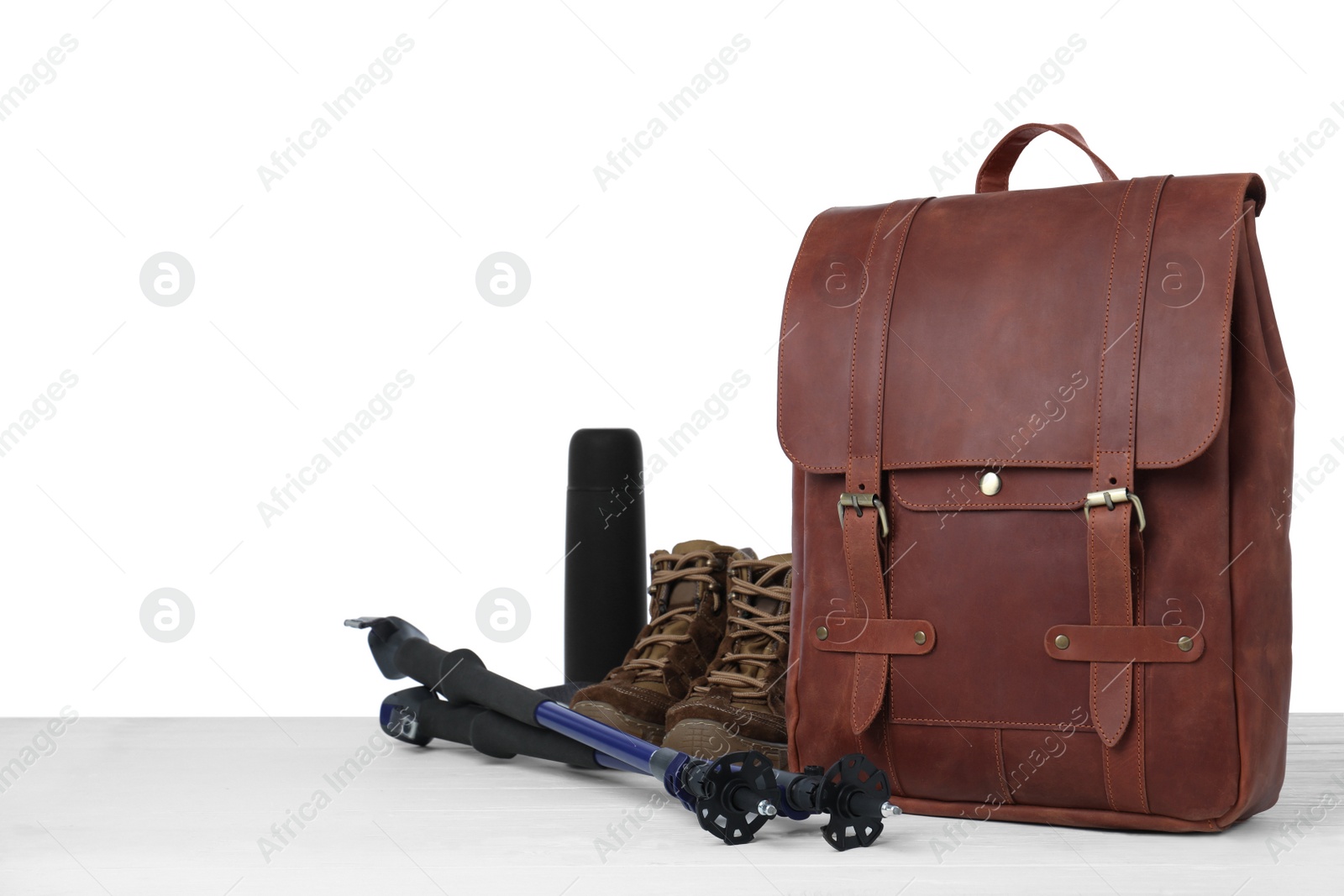 Photo of Set of camping equipment for tourist on wooden surface against white background