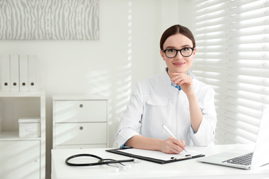 Photo of Portrait of young female doctor in white coat at workplace