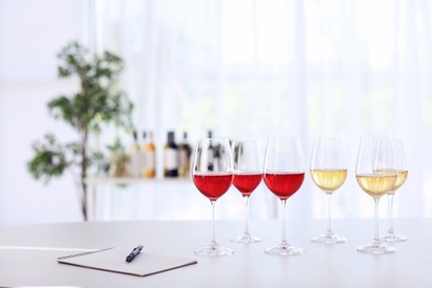 Photo of Glasses with delicious wine on table indoors