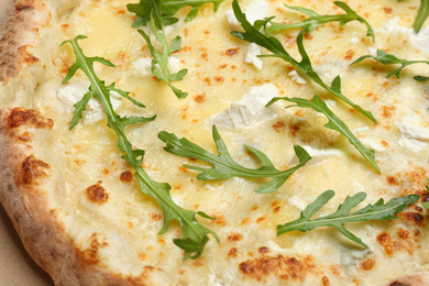 Photo of Delicious cheese pizza with arugula as background, closeup